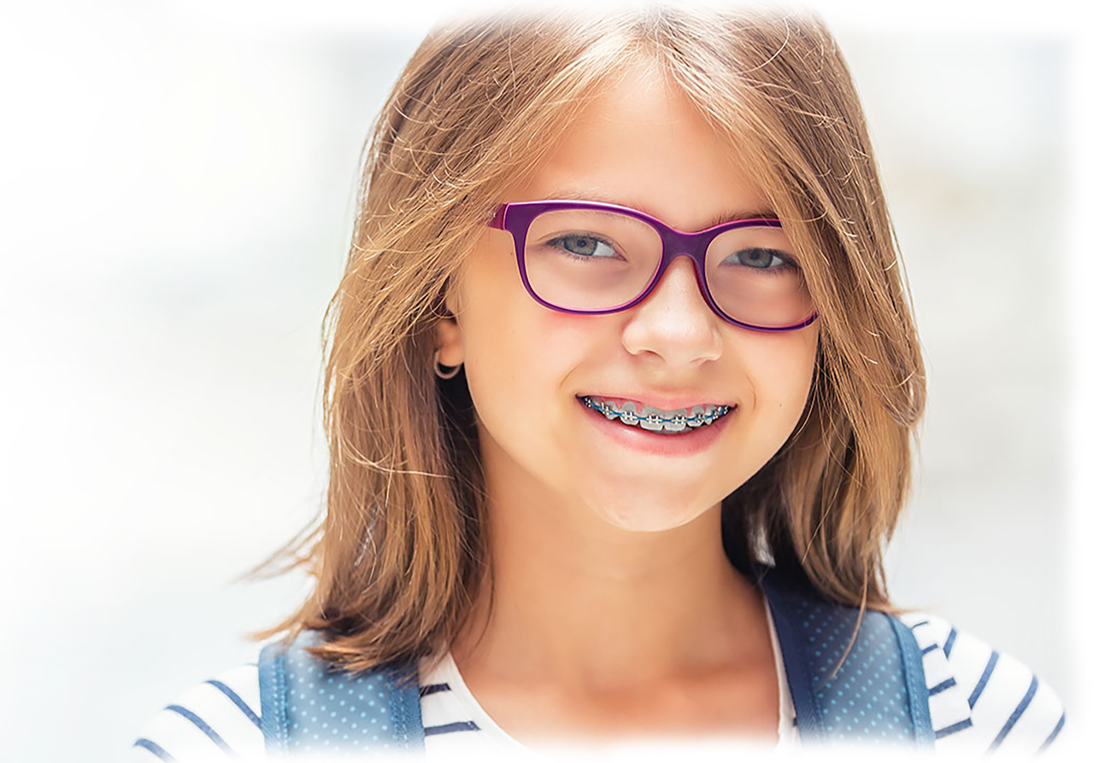 Girl with glasses and braces smiling