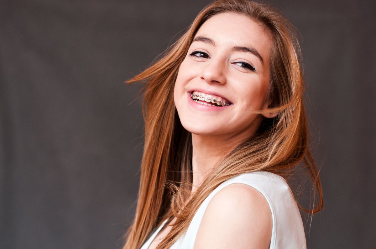 Teenager smiling with metal braces on their teeth